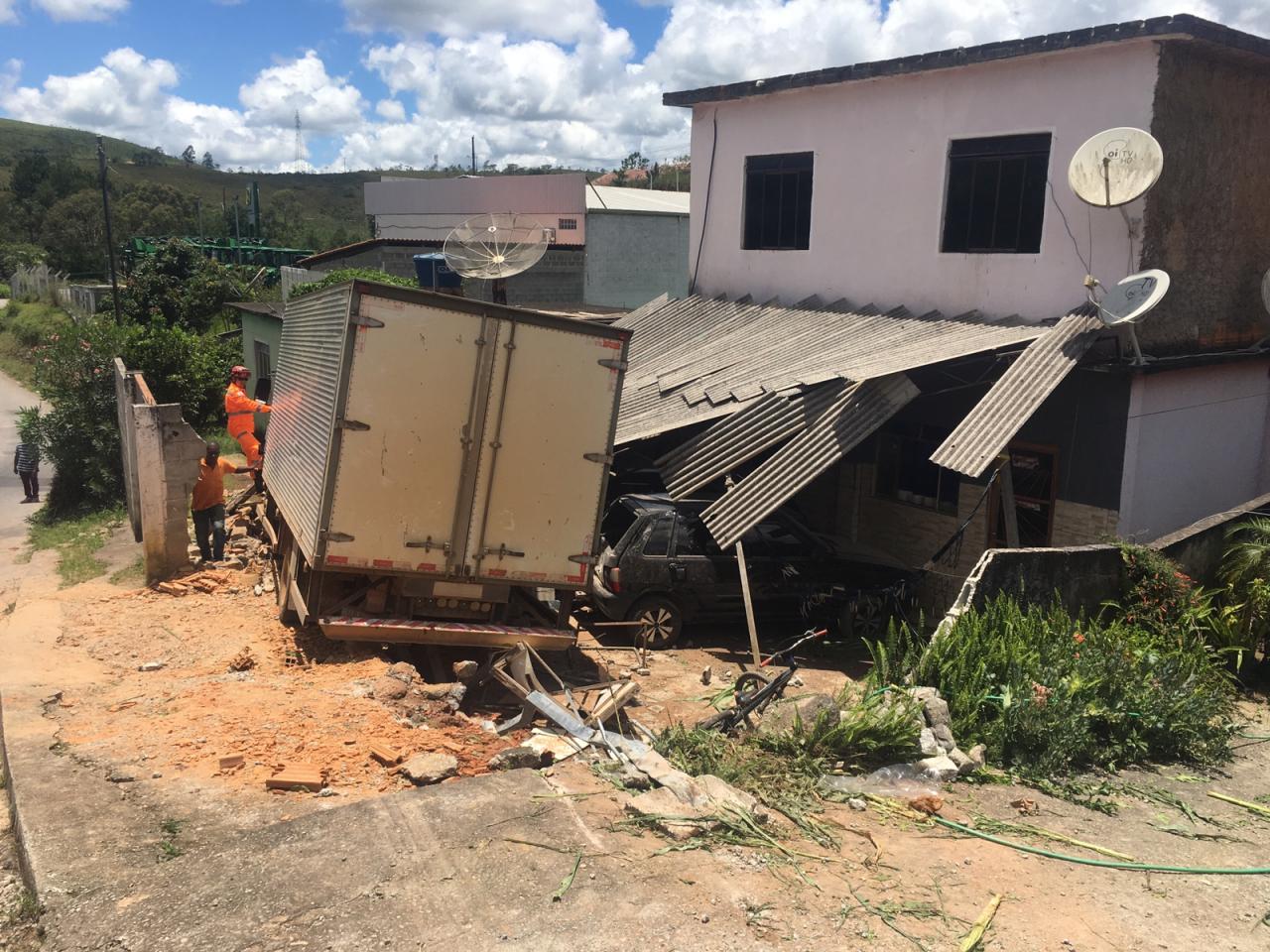 Bombeiros Militares realizam atendimento de uma colisão entre um caminhão em uma residência e dois automóveis em Barbacena