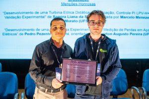 Alunos Giovani Castro e Pedro Butturini durante premiação no Simpósio Brasileiro de Automação Inteligente. Fonte: Arquivo pessoal
