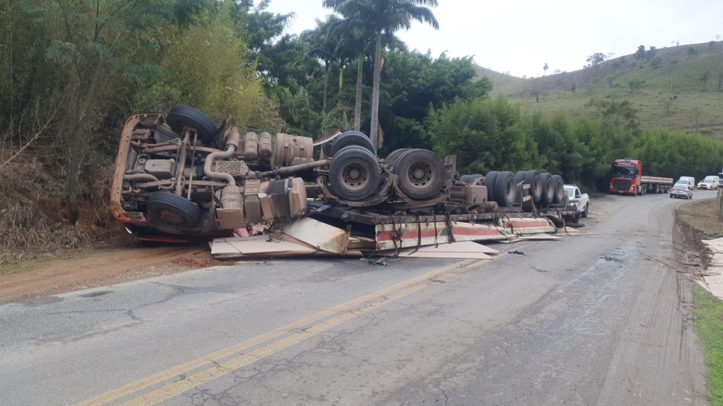 Caminhão carregado de MDF tomba após passar por buraco na MGC-265, em Mercês