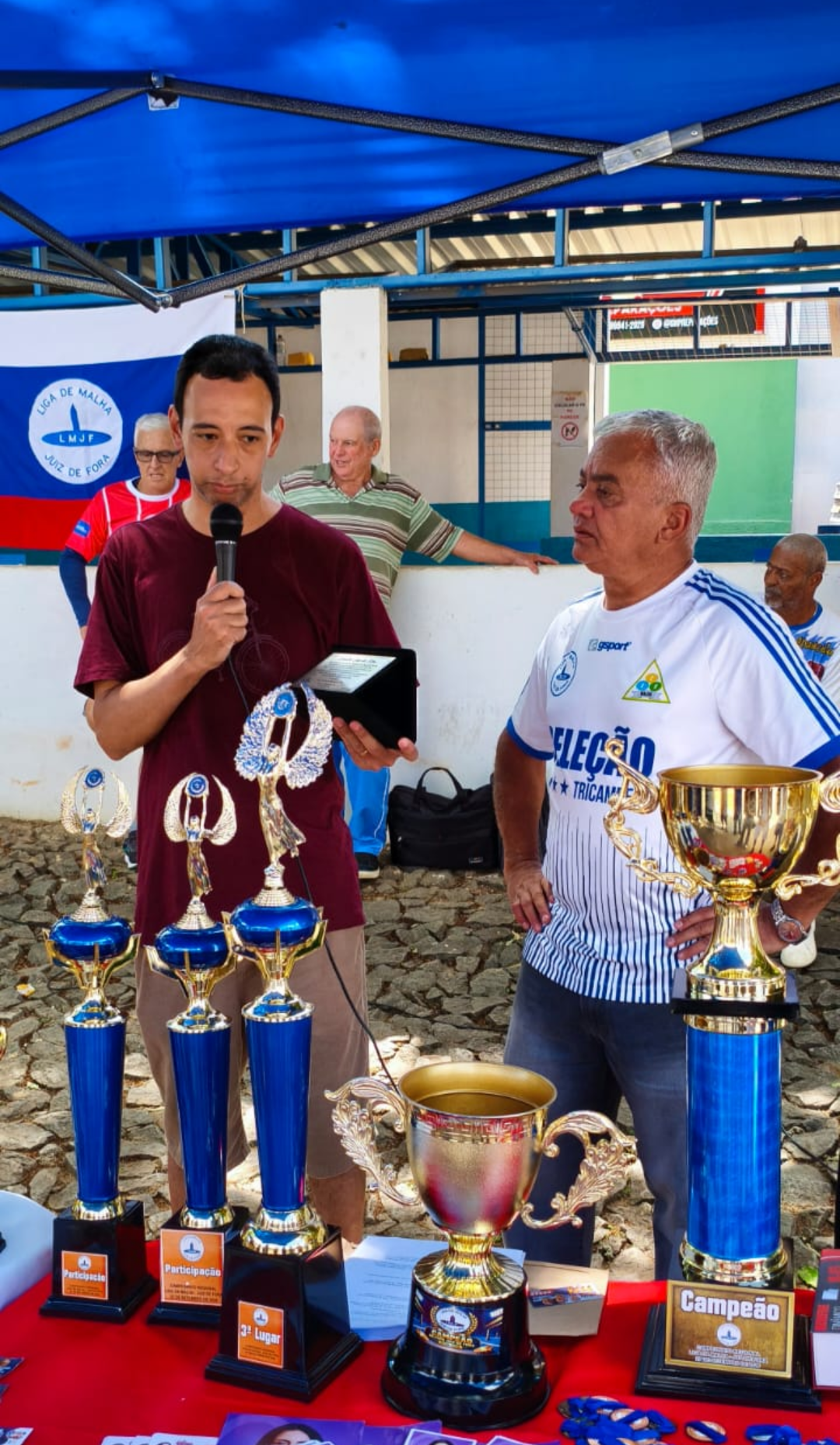 O jornalista Leandro Dias recebeu a homenagem das mãos do presidente da Liga de Malha de Juiz de Fora, Eduardo Poggianella, durante a solenidade de encerramento da competição. Foto: Raul Souza.