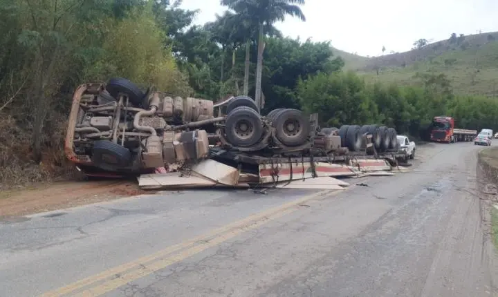 Caminhão carregado de MDF tomba após passar por buraco na MGC-265, em Mercês